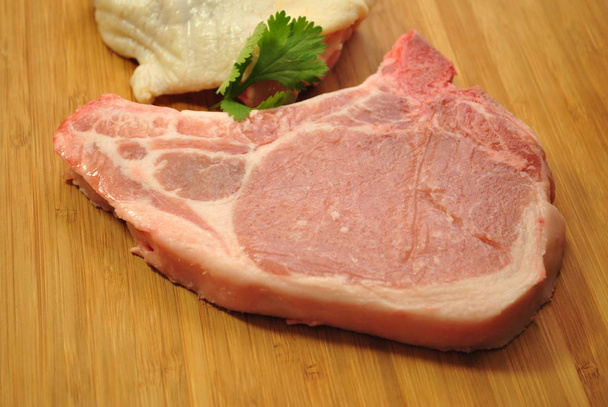 Côtelette de porc crue garnie de persil
  - Photo, image