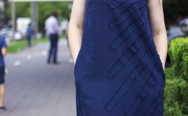 Mujer joven en vestido de lino azul oscuro cogido de la mano en los bolsillos, verano, moda
 - Foto, Imagen