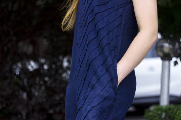 Mujer joven en vestido de lino azul oscuro cogido de la mano en los bolsillos, verano, moda
 - Foto, Imagen