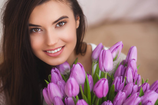 Beautiful woman with flowers indoors - 写真・画像