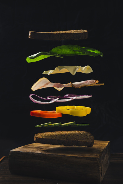 Flying Food Sandwich mit Gurken Zwiebeln Pfeffer Speck Käse und Spinat - Foto, Bild