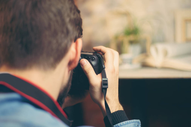 DSLR camera in young photographer hands shooting objects in indoor photo studio - Foto, Imagen
