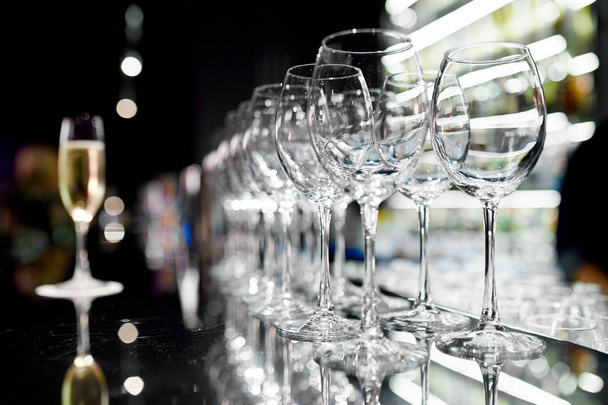 A glass of champagne and empty wine glasses  - Фото, изображение