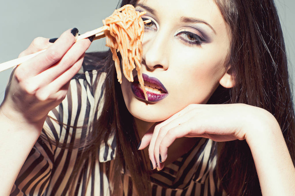 Pasta with tomato ketchup on chopsticks. Pasta dish for sensual woman - Photo, Image