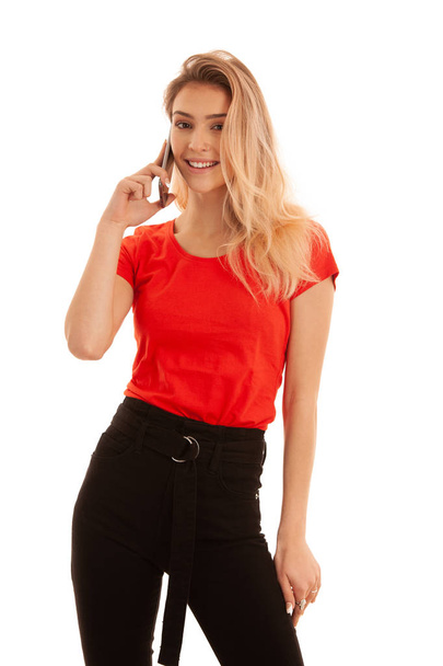 Beautiful young woman in red t shirt speak on a smart phone isolated over white background - phone chat - 写真・画像