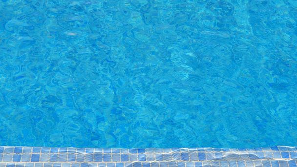 Fondo de agua de la piscina con azulejos de mosaico en un extremo, textura de la superficie del agua con efecto de ondulación, concepto para vacaciones de verano, relajación o trabajo desde casa, patrón natural con espacio de copia
 - Foto, Imagen
