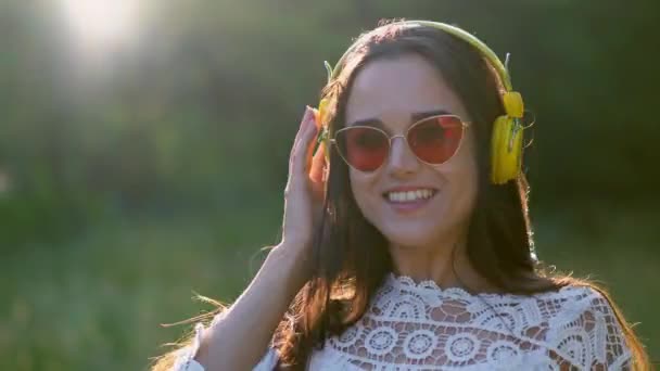 Piękna dziewczyna w romantyczny obraz słucha słuchawki z przyjemną muzyką. - Materiał filmowy, wideo