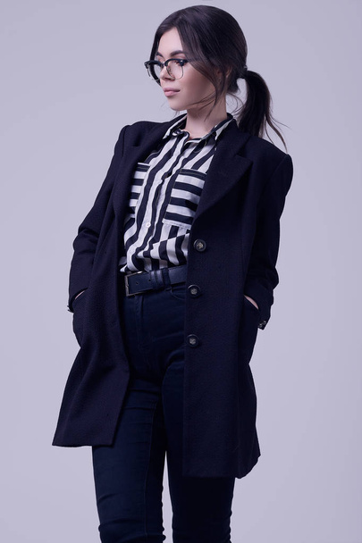 Portrait of fashion brunette woman wearing a striped blouse and black jacket isolated on white background in studio - Foto, afbeelding