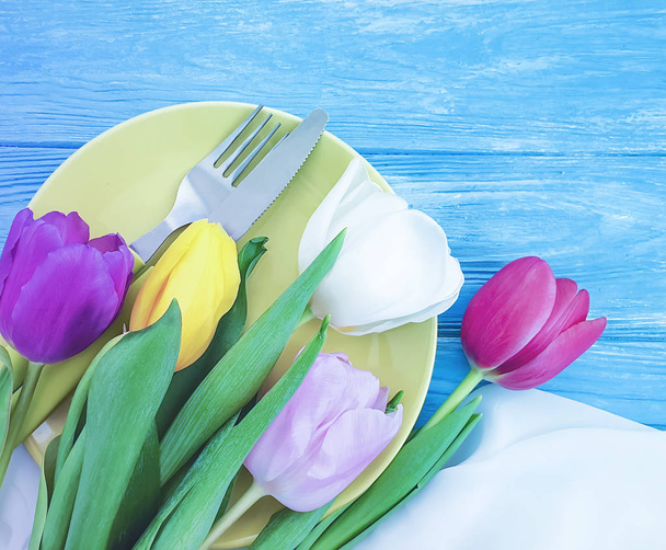 plate, a bouquet of tulips on a wooden background - Fotoğraf, Görsel
