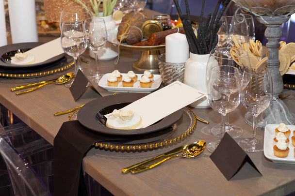 Close up van een volledig set feestzaal tabel met bruin- en aardetinten, lege papier voor het menu en de naam tag - Foto, afbeelding