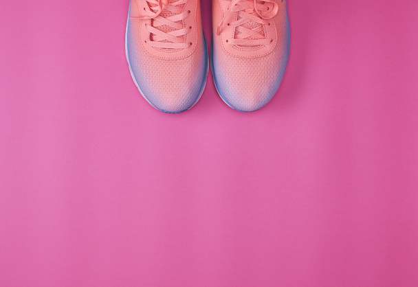 par de zapatillas con cordones en un fondo rosa, vista superior, espacio para copiar
  - Foto, imagen