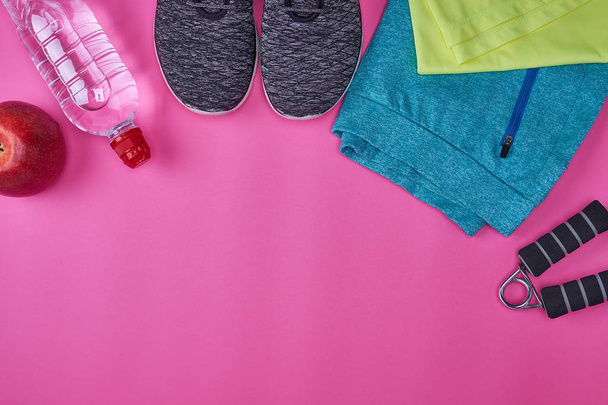 γυναικεία αθλητικά ρούχα και είδη γυμναστικής σε ροζ φόντο, διάστημα αντίγραφο, κάτοψη - Φωτογραφία, εικόνα