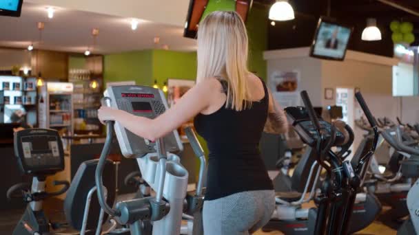 Young and sexy girl is running on a stepper at the gym - Filmmaterial, Video