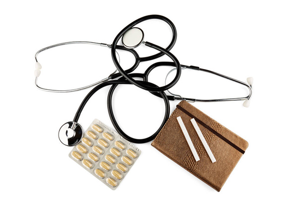 Twee stethoscopen, blister met geneeskunde, gouden notitieboekje en sigaretten. Geïsoleerd. - Foto, afbeelding