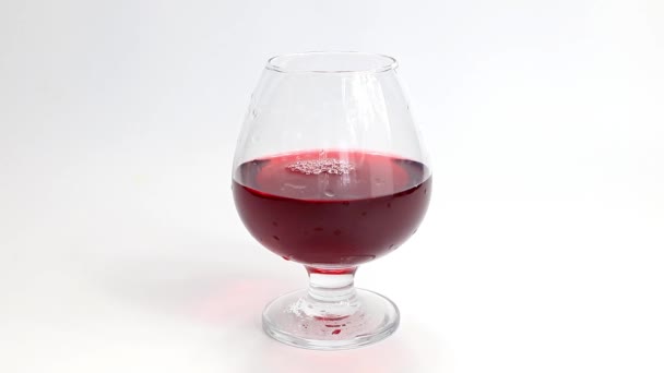 delicate highlights and patterns on the surface of red wine in a glass - Video