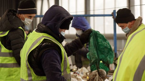 Працівники на заводі з переробки відходів. Сортування сміття на конвеєрній стрічці
 - Фото, зображення