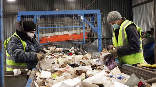 Jätteenkäsittelylaitoksen työntekijät. Roskien lajittelu kuljetinhihnalla
 - Valokuva, kuva