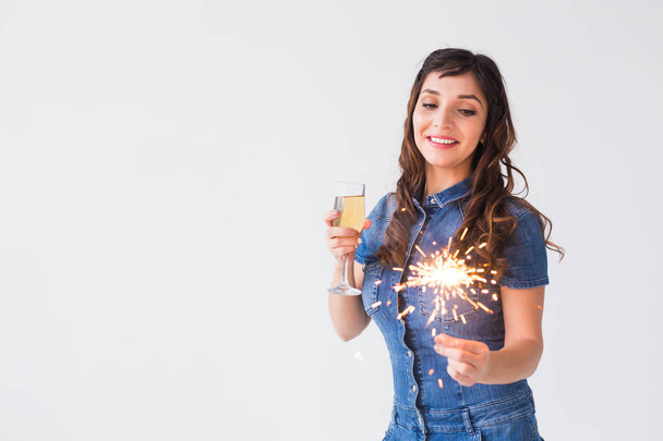 Люди, праздник и концепция праздника - Веселая женщина с искрой и бокалом шампанского на белом фоне с пространством для копирования
 - Фото, изображение