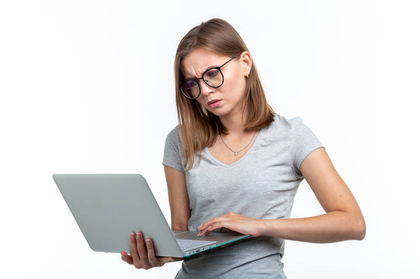Study, education, people concept - young woman student in glasses texting something on laptop and looks like she is very busy - Φωτογραφία, εικόνα