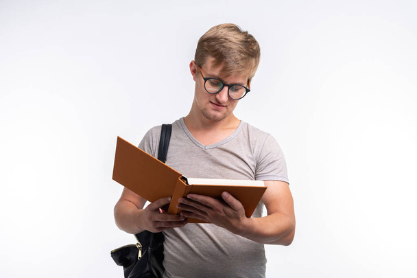 People, knowledge and education concept - Student man reading a book over white background - Foto, Imagem