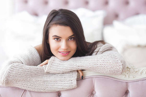 Young attractive woman indoors. Girl on neutral background. Happy woman. Female in the bedroom at home. Close up portrait of beautiful lady. - Foto, imagen