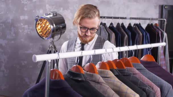 Jeune homme élégant choisit costume classique en magasin
 - Séquence, vidéo