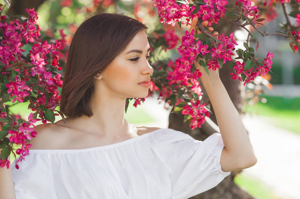 Close up portrait of young beautiful woman with perfect smooth skin. Attractive lady in flowers. Facial portrait of beautiful female. - Foto, Imagem