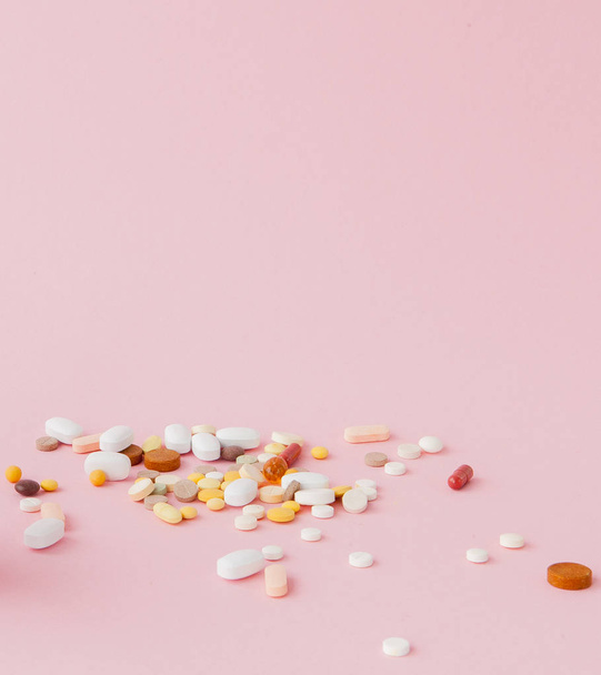 группа капсул и таблеток в разных цветах и форме изолированы на розовом фоне
. - Фото, изображение