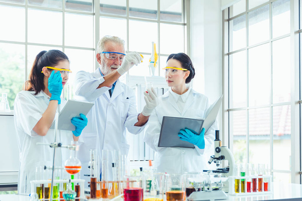 Zespół nauczycieli nauk ścisłych i studentów pracujących z chemikaliami w laboratorium - Zdjęcie, obraz