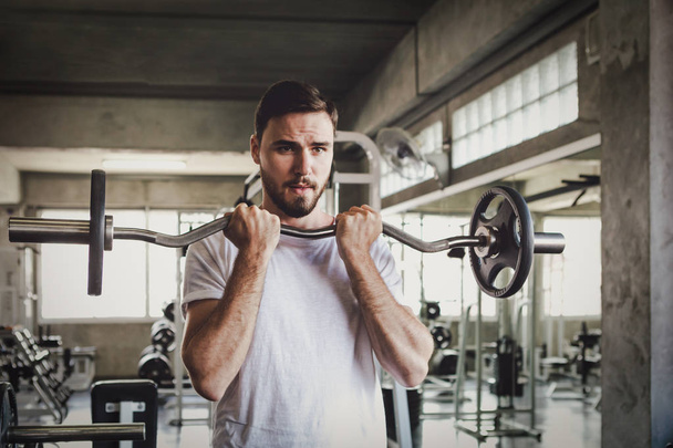 Vértes férfi egészséges gazdaság súlyzó edzés és épület test edzőteremben fitness - Fotó, kép