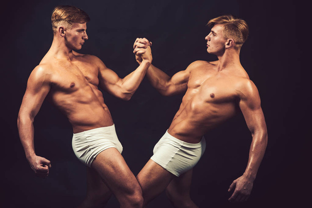Friendship of men do gymnastic. friendship of twins men with muscular body in bodybuilder pose. - Фото, зображення