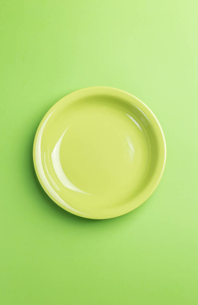 Green plate on green background,above view.Useful as a food background - Photo, Image