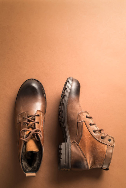 Коричневі шкіряні чоботи на коричневому фоні, над видом з пробілом для тексту або іншого
 - Фото, зображення