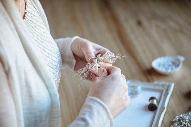 Closeup macro photo of details, workplace of decorator and creator of wedding imitation jewelry. Woman's hands in a process of creation - 写真・画像