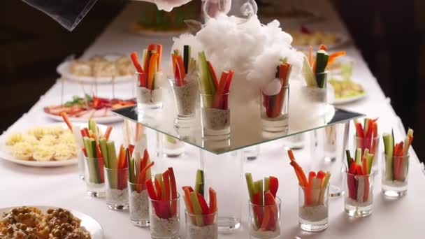 Leckere Vorspeisen serviert in Glasgläsern mit frittiertem Eisrauch auf dem Tisch - Filmmaterial, Video