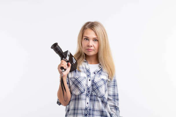Technologien, Fotografie und Personenkonzept - blonde junge Frau mit Retro-Kamera lächelt über weißem Hintergrund - Foto, Bild