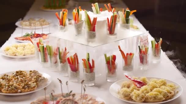 Concepto de comida en una fiesta. Sabrosos aperitivos servidos en frascos de vidrio con humo de hielo frito en la mesa
 - Metraje, vídeo