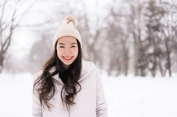Красиві азіатські брюнетки посміхаючись щаслива з подорожі в снігу зимового сезону на Хоккайдо, Японія - Фото, зображення