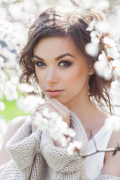 Close up portrait of young beautiful woman on spring background. Attractive young girl with flowers. Spring make up model. - Photo, Image