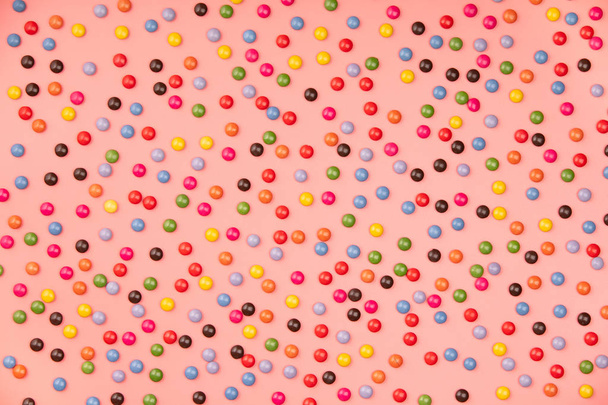 Colorful sprinkles on pink background, flat lay, top view - Fotó, kép