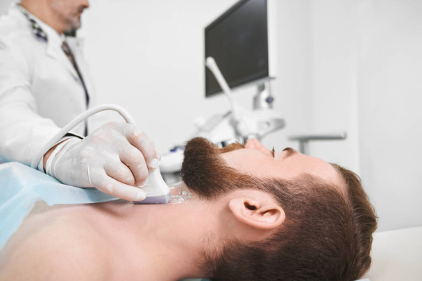 Doctor using ultrasound probe for lymph node diagnosis. - Фото, зображення