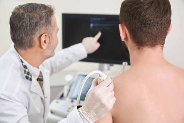 Ultrasound diagnosis of mans shoulder in equipped clinic. - Valokuva, kuva