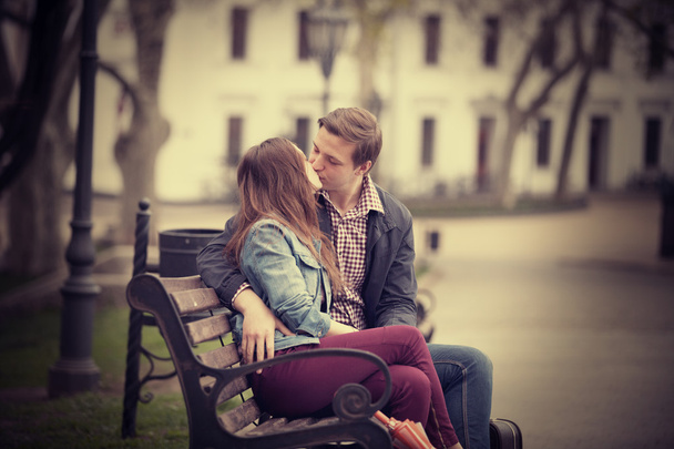 Couple kissing at the bench at alley. - Фото, изображение