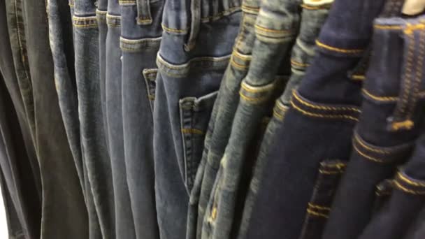Close up van veel jeans in de winkel. 4 k-beeldmateriaal in het winkelcentrum. - Video