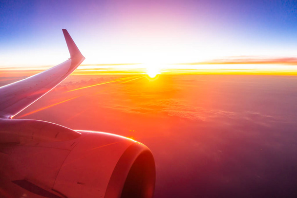 Όμορφη Αεροφωτογραφία από φτερό αεροπλάνου σε λευκό σύννεφο και τον ουρανό στο ηλιοβασίλεμα ή sunrise χρόνο - Φωτογραφία, εικόνα