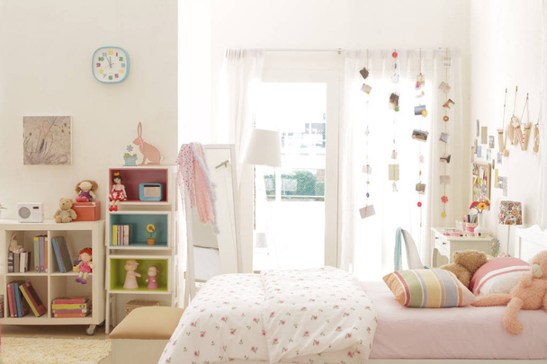 bir genç kız yatak odasında yatak ve bayağı hoş bir şekilde dekore edilmiş eşya yan görünüm - Fotoğraf, Görsel