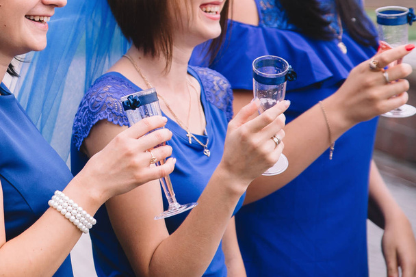 Холостяцкая вечеринка, девушки в голубых платьях с бокалами шампанского веселятся
 - Фото, изображение