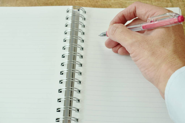  hand schrijven op wit papier boek binding - Foto, afbeelding