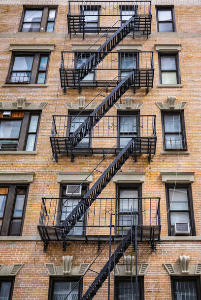 NEW YORK, USA - Apr 28, 2016: Escape fire ladders at house facades in New York. Manhattan NYC - 写真・画像