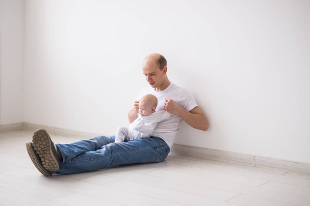 Vaderschap, ouderschap en baby concept - kale vader met plezier met zijn kleine dochtertje - Foto, afbeelding